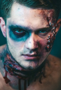 Zombi makyajlı bir adamın yakın çekim portresi. Korku ile Korkunç yüz adam Balkabağı baş jack fener tutarak makyaj. Cadılar Bayramı yüz sanatı. Yarım yüz portresi. Korkunç ve kanlı kaslı zombi adam