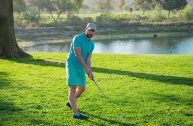 Golf sahasında profesyonel bir golfçü. Golfçü atış yapıyor.