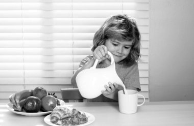 Küçük tüylü çocuk kahvaltı için bütün inekleri sağıyor. Çocuklar için sağlıklı beslenme. Tatlı çocuk sabah kahvaltısında iştahla yemek yemekten hoşlanır. Aç çocuk lezzetli meyve ve sebze yer.