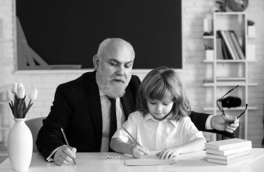 Öğrenci çocuk dersi. Lise son sınıf öğretmeni. Eğitim konsepti. Yaşlı büyükbaba ve okul çocuğu sınıfta.