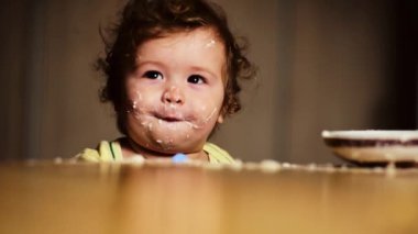 Sevimli bir bebek kaşıkla yemek yer. Çocuk maması yiyen aç küçük bir çocuk. Bebek yulaf lapası. Yemek zamanı. Küçük bebek sağlıklı yiyecekler yiyor. Küçük bir bebek yemeğini yiyor. Yiyeceği olan çocuğun yakın plan portresi
