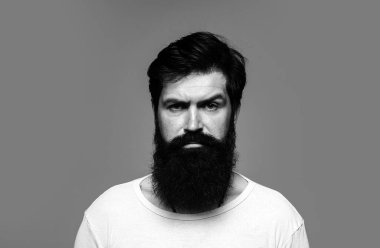 Kendine güvenen ciddi bir adamın portresi sakalı ve bıyığı var, ciddi ve izole görünüyor. Stüdyodaki hippi adam modelleri. İş adamı kendini ifade ederek düşünür. Yakışıklı erkek model, yakın çekim yüzü.