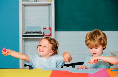 Neşeli gülümseyen çocuklar tahtaya tırmanıyor. İlkokuldan bir çocuk.