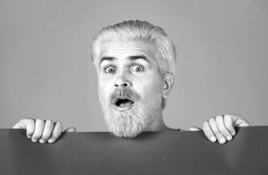 Boş kart tutan heyecanlı adam. Mutlu orta yaşlı adam boş kağıt sunuyor.