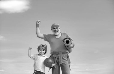 Grandpa and grandson spotting. Grandfather and child is doing sport outdoors. Different generations. Active family enjoy sport and fitness