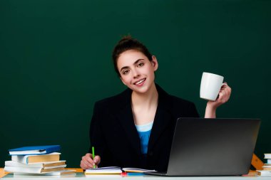 Öğrenci sınıfta kahve içiyor. Üniversitede kahve molası. Öğrenci kız kahve fincanı tutuyor. Öğrenci ergen sınıfta öğreniyor. Öğrenci kız okulda.