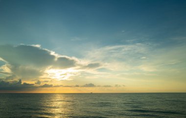 Dramatik gün batımı gökyüzü. Deniz. Bulutların arasından gün batımını izleyen sakin bir deniz. Günbatımı okyanusu ve gökyüzü arka planı. Huzurlu deniz manzarası. Günbatımı deniz suyunun üzerinde bir ufuk. Güneşin doğuşuyla sakin deniz