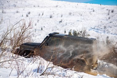 Kış lastikleri. Dağlarda karlı yollarda. Kar altında off-road aracı. Ormanda bir arazi aracı, karda sürükleniyor. Kar fırtınasında off-road arazi aracı. Arabalar off-road gezisi, kış off-road pisti