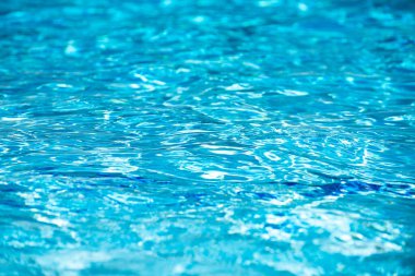 Su arka planı, dalgalanma dalgaları. Mavi yüzme havuzu deseni. Deniz yüzeyi. Yüzme havuzunda su ve güneş yansıması. Kopyalama alanı olan pankart