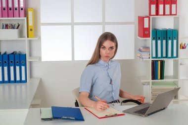 Dizüstü bilgisayarla çalışan genç kadın müfettiş. Raporlar, belgeler. Ofiste çalışan kadın müfettiş. Kağıt işlerine odaklanmış finansör muhasebecisi