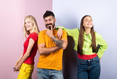 Stüdyoda poz veren bir grup arkadaş. Bir grup ağaç adam. Arkadaş yüzü. Üç genç insan portresi. Harika bir takım. Sıradan giyinmiş üç neşeli genç, kameraya bakıyor.