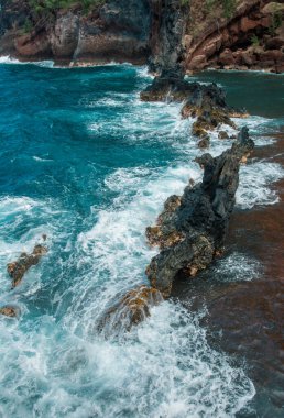 Kayalık kayalıkları olan deniz kıyısı. Mavi su ve deniz kıyısında büyük taşlar. Sahildeki kayalar, yaz arkaplanı.