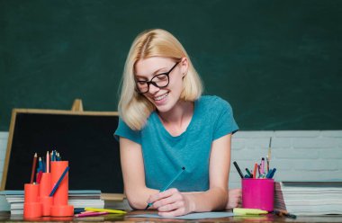 Üniversite öğrencisi üniversiteye gidiyor. Sınıfta öğretmen. Sınava veya sınava hazırlanan öğrenci. Genç kadın masada oturmuş ödevkütüphanesini yapıyor. Genç öğretmen