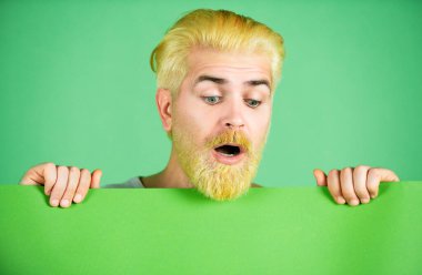 Elinde reklam panosu olan, yeşil stüdyo geçmişi olan bir adam.