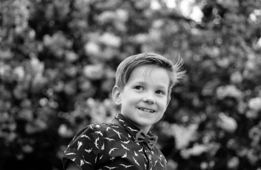 Gülümseyen mutlu çocuk pembe çiçekli Japon sakura arka planında. Bahar çiçekleri açar.