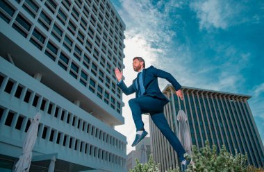 Şehir arka planında hızlı koşan bir iş adamı