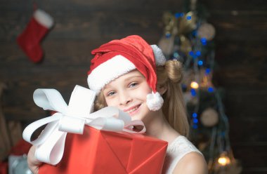Bir Noel Noel Baba şapkası hediye ile mutlu küçük genç var. Mutlu Noeller ve mutlu tatiller. Çocuk hediye. Kış akşam evde. Yeni yıl çocuklar. Genç yeni yıl