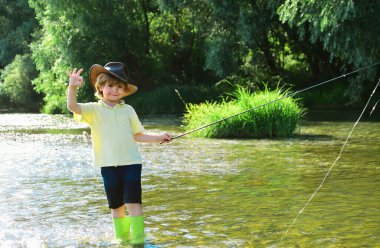 Küçük çocuk hafta sonu balık tutarken olta çekiyor. Balıkçı çocuk güzel nehirde olta kullanıyor. Tatlı çocuk yazın nehirde balık tutuyor.