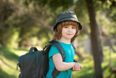 Sırt çantalı küçük bir çocuk manzaralı dağlarda yürüyüş yapıyor. Çocuk yerel bir turist yerel bir yürüyüşe çıkıyor..