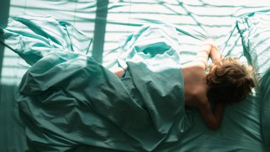 Çocuk uzanıyor ve yastığın üzerinde uyuyor. Sabah yatak odasında rahat bir şekilde uyuyan çocukların en iyi görüntüsü.