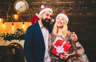 Christmas decorations and gift box on wooden background. Portrait of surprised and funny couple. Christmas couple in love clipart