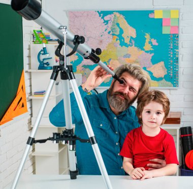 Öğrenci bir öğretmenle yıldızları izliyor. Astronomi teleskopu. Baba oğul öğretiyor