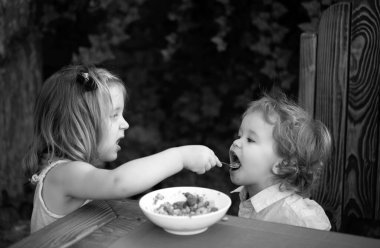 Sevimli bebek maması, bebeklerin yemek yemesi. Küçük kız kardeş bebeği besliyor. Afiyet olsun