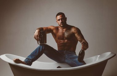 Elit alkol. Lüks elit eğlence. Bir şişe şampanya onun elinde ile çekici bir adam. Acımasız adam alkol ile