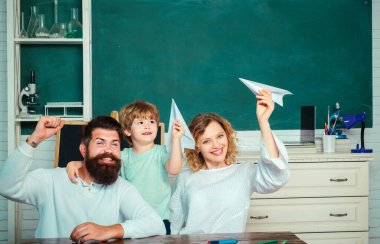 Okula dönüyoruz. Ebeveyn ile oynayan kağıt uçak ile öğrenci. Aile Okulu. Anaokulundaki çocuklar. Çocuk eğitimi ve öğrenciler eğitimi