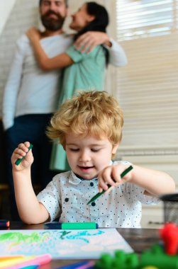 Anne ve baba çocuklu resim çiziyor. Aile eğlencesi, mutlu anne, baba ve küçük çocuk. Evde mutlu ve sevgi dolu bir aile. Çocukluk eğitimi, çocukların sanatsal becerileri.