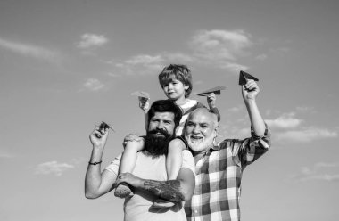 Üç erkek nesli. Babasıyla dışarıda oynayan sevimli bir oğlu var. Babalar Günü - Büyükbaba, baba ve oğul kucaklaşıyor ve birlikte eğleniyorlar.