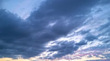 Alacakaranlık Gökyüzü zaman dilimi. Hareket eden bulutlar ve günbatımı. Bulutlar akşam boyunca yüzer. Alacakaranlık gökyüzü zaman aşımına uğradı. Dramatik gökyüzü hareket ediyor. Kümülüs ve sirrus fırtınada. Gün doğumu bulutu