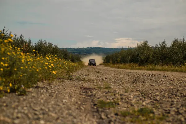 Tekerlekleri ve kumdaki toza dönüşen off-road 'u hareket ettir. Sürüklenen yarış arabası lastik yakar. Aşırıya kaçmış. Off-road arabası. Off-road aracı dağ yolunda gidiyor.