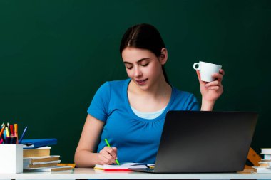 Üniversite sınıfındaki öğrenci kız. Üniversitede bilgi. Lisedeki ya da üniversitedeki liseli kız. Üniversite öğrencisi tahtanın yanında öğreniyor. Eğitim konsepti. Üniversitede ders ve ödev