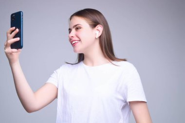 Stüdyonun arka planında izole edilmiş telefon aygıtı uygulaması kullanan bir kız. Akıllı telefon tutan, cep telefonuyla konuşan bir kadın. Telefon kullanan bir kız, stüdyo resmi. Kadın telefonla konuşuyor.