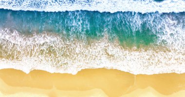 Yaz deniz dalgalarının en üst görüntüsü. Güneşli bir günde mavi deniz suyu. İHA 'dan hava görüntüsü. İnanılmaz tropikal doğa geçmişi. Sakin deniz dalgaları kumsala vuruyor.