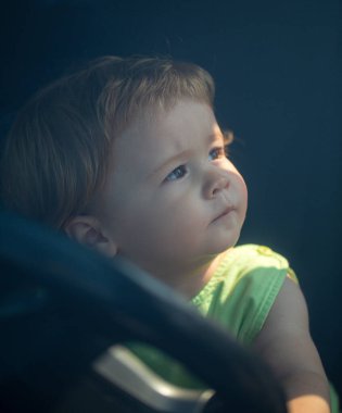 Küçük Bebek Şoförü. Bebek arabada, elleri direksiyonda. Çocuk Sürücüsü. Küçük çocuk araba kullanıyor. Çocuk direksiyonda oturuyor. Arabayla oynayan çocuk. Rüya, hayal gücü, çocukluk. Çocuklar Seyahat