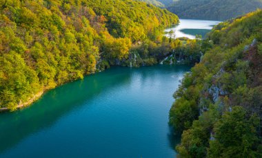 Plitvice Lakes Ulusal Parkı. Hırvatistan. Büyük şelaleler. Doğa yolculuğu geçmişi. Güzel yaz doğası. Hırvatistan 'daki Plitvice şelaleleri. Dağ dereleri masmavi berrak suyla bir göle akar.