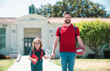 Outdoor school. Father and son come back from school. School, family, education and outdoor concept clipart