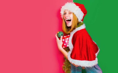 Funny winkingh woman with christmas ball. Pretty lady celebrate winter holidays hold christmas balls on isolated background Young beautiful girl with christmas ball clipart