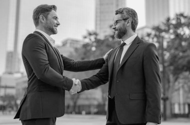Amerikalı işadamı ortağıyla tokalaşıyor. Dışarıda el sıkışan iki işadamı. El sıkışıyoruz. Yönetim stratejisi. İki işadamı arasında tokalaşma. İş konsepti iletişimi