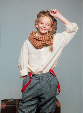 Macera. retro erkek takım elbiseli genç kız. Kirli suratlı sokak çocuğu. vintage İngilizce tarzı. Eski bavulla seyahat edin. Homelss, ne kadar çok şey var? bere eski moda çocuk. retro model. Vintage askı.