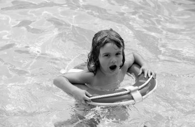 Havuzda yaz partisi. Yüzme havuzunda mutlu bir çocuk. Çocuk Aquapark 'ta eğleniyor. Yüzme yüzüklü çocuk