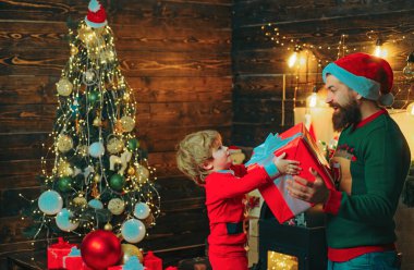 Çocuklar Noel tatilinden keyif aldı. Mutlu baba ve oğul dekorasyon Noel ağacı. Noel ailesi. Noel öncesi sabah