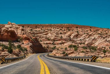 Long Desert Highway California 'da. Yüksek kayalıklara karşı yol. Tepe köy yolu