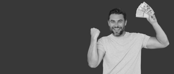 Хорошая оплата. Красавчик, держащий деньги в изоляции над красной студией, пространство для баннеров. Деньги в банкнотах. Куча наличных, финансов, инвестиций и сбережений. Мокап-баннер