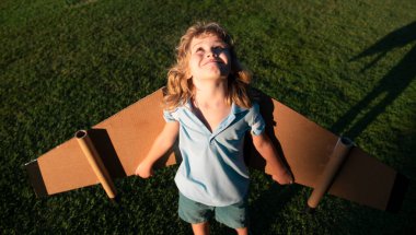 Çocuk çocuk oyuncak uçak kanatlarıyla oynuyor. Bir pilot olmayı hayal et. Süper kahraman uçuyor.