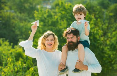 Dışarıda eğlenen insanlar. Mutlu baba portresi oğlu omuzlarında piggyback binmek veren ve yukarı bakıyor. Dost aile kavramı. Komik zaman. Aile tatili ve birliktelik