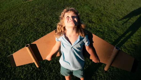 Çocuk çocuk oyuncak uçak kanatlarıyla oynuyor. Bir pilot olmayı hayal et. Süper kahraman uçuyor.