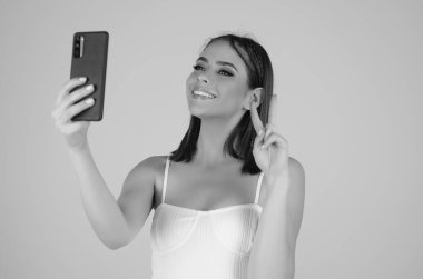 Stüdyonun arka planında izole edilmiş telefon aygıtı uygulaması kullanan tatlı bir kız. Akıllı telefon tutan, cep telefonuyla konuşan bir kadın. Telefon kullanan bir kız, stüdyo resmi. Kadın telefonla konuşuyor.